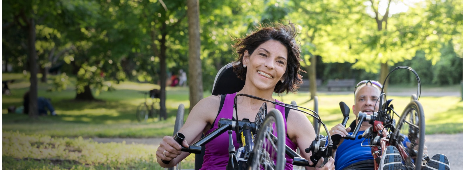 Becky patiente en fauteuil roulant atteinte de troubles colorectaux en train de faire du vélo à main